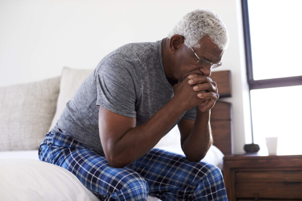 Stressed, depressed older man in bed