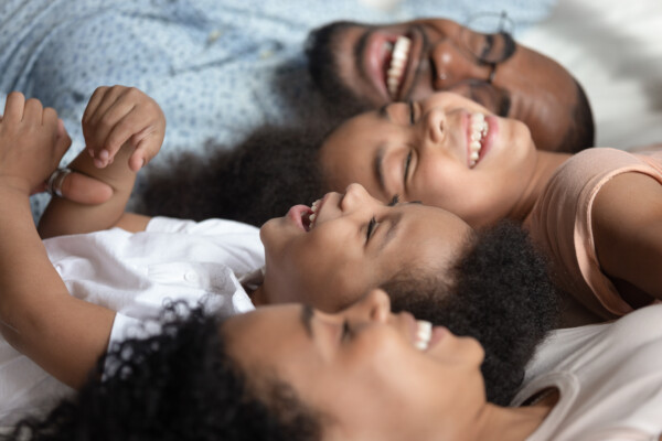 Family, parents and children lying on bed