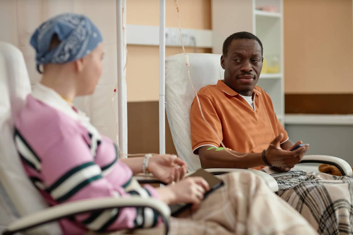 Man talking to another patient during chemotherapy treatment