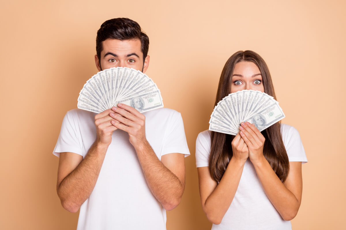 Couple holding hundred dollar bills