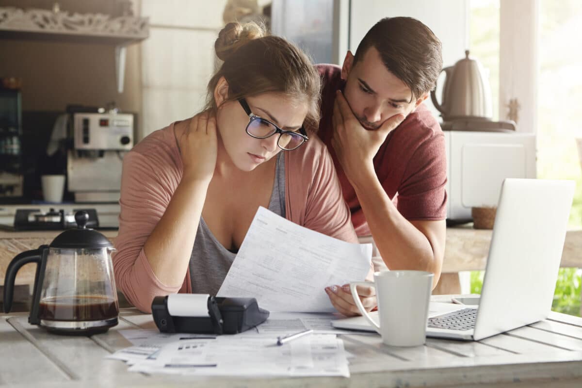 Couple looking at bills amid financial struggles