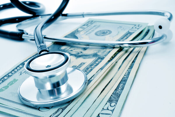 Stethoscope on a pile of cash to represent medical bills and healthcare costs