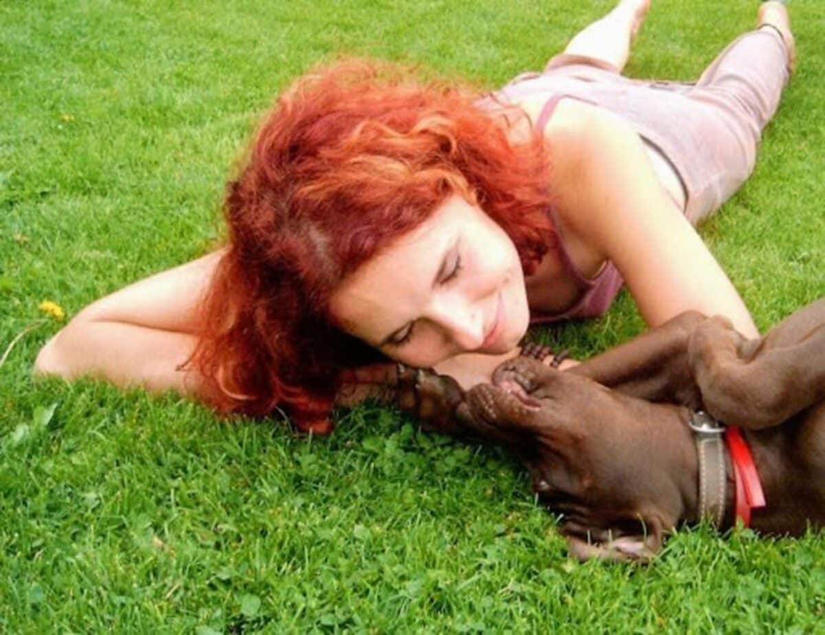 Dog and owner cuddling on grass