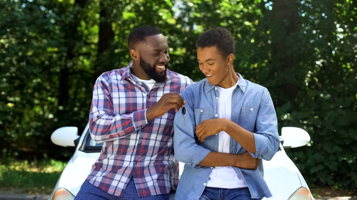 Excited teen driver gets the car keys from his dad